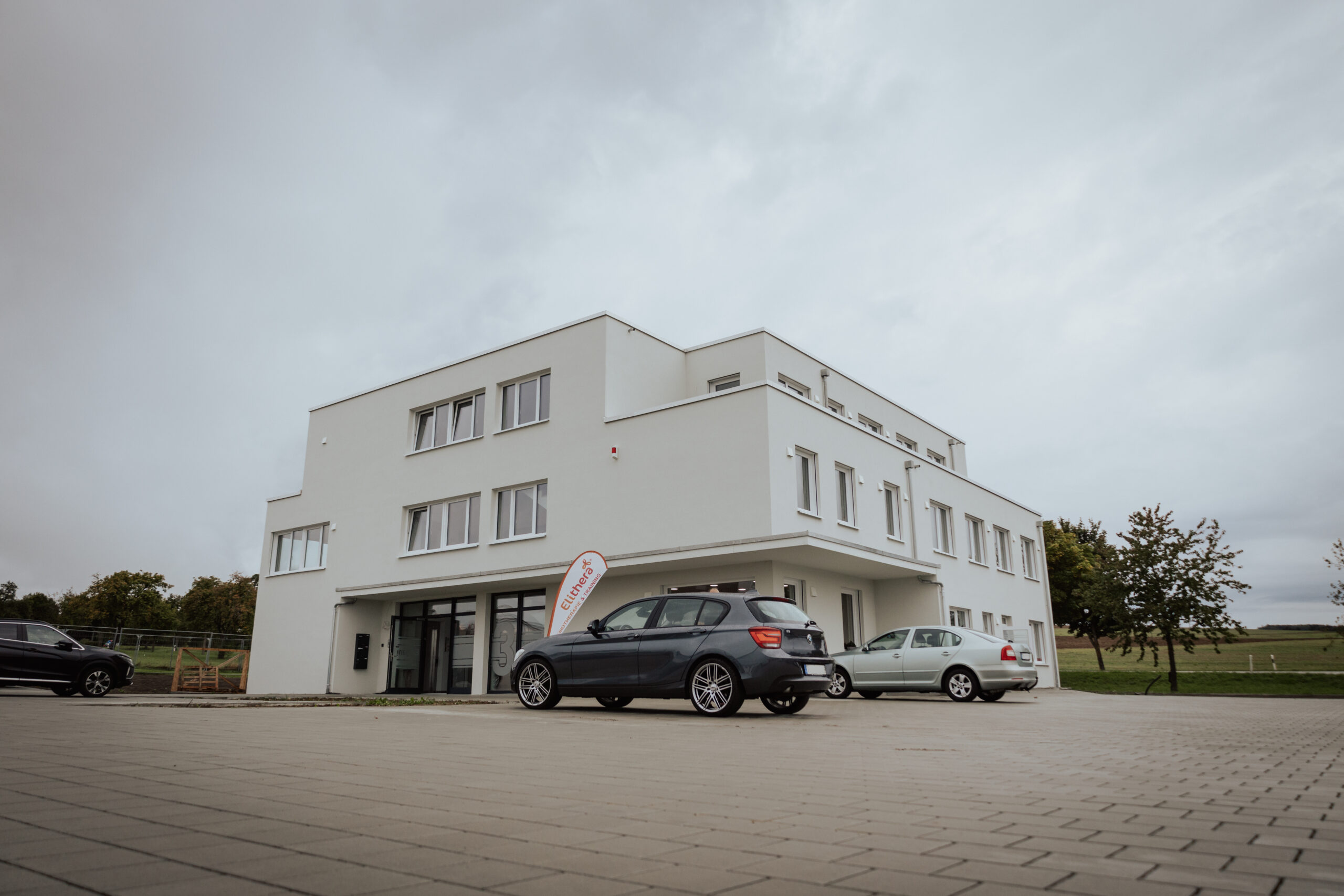 Außenansicht des Elithera Gesundheitszentrums am Witthoh mit modernem Gebäude und Parkplatz.